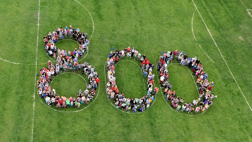 öffnet internen Link in aktuellem Fenster zeigt aus der Vogelperpektive auf einer Wiese eine von Kindern gebildete "800"