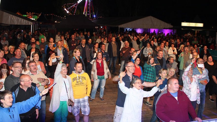 zeigt zuschauende Festbesucher am Abend