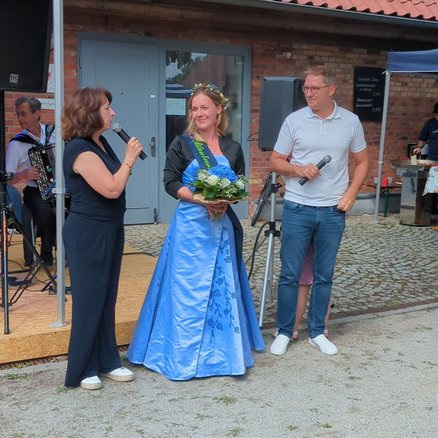 zeigt mehrere Personen und die Bürgermeisterin bei der Begrüßungsansprache für die Blaubeerkönigin