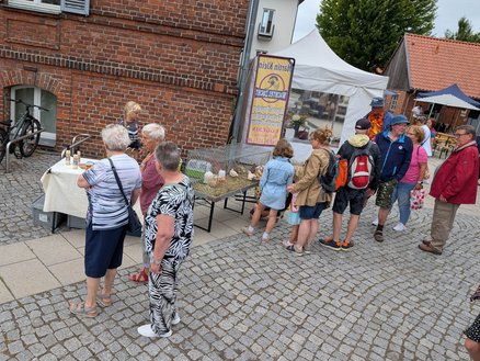 zeigt eine Personengruppe, die Marktangebote betrachtet